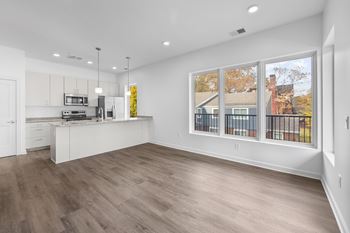 A kitchen with white cabinets and a wooden floor. at The Lumos Apartments, Cleveland 44106